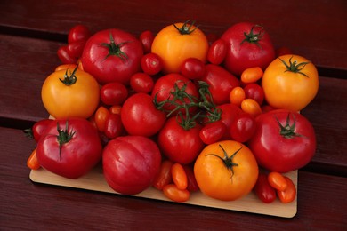 Photo of Many fresh tomatoes on wooden surface, closeup view