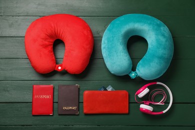 Photo of Flat lay composition with colorful travel pillows on green wooden background