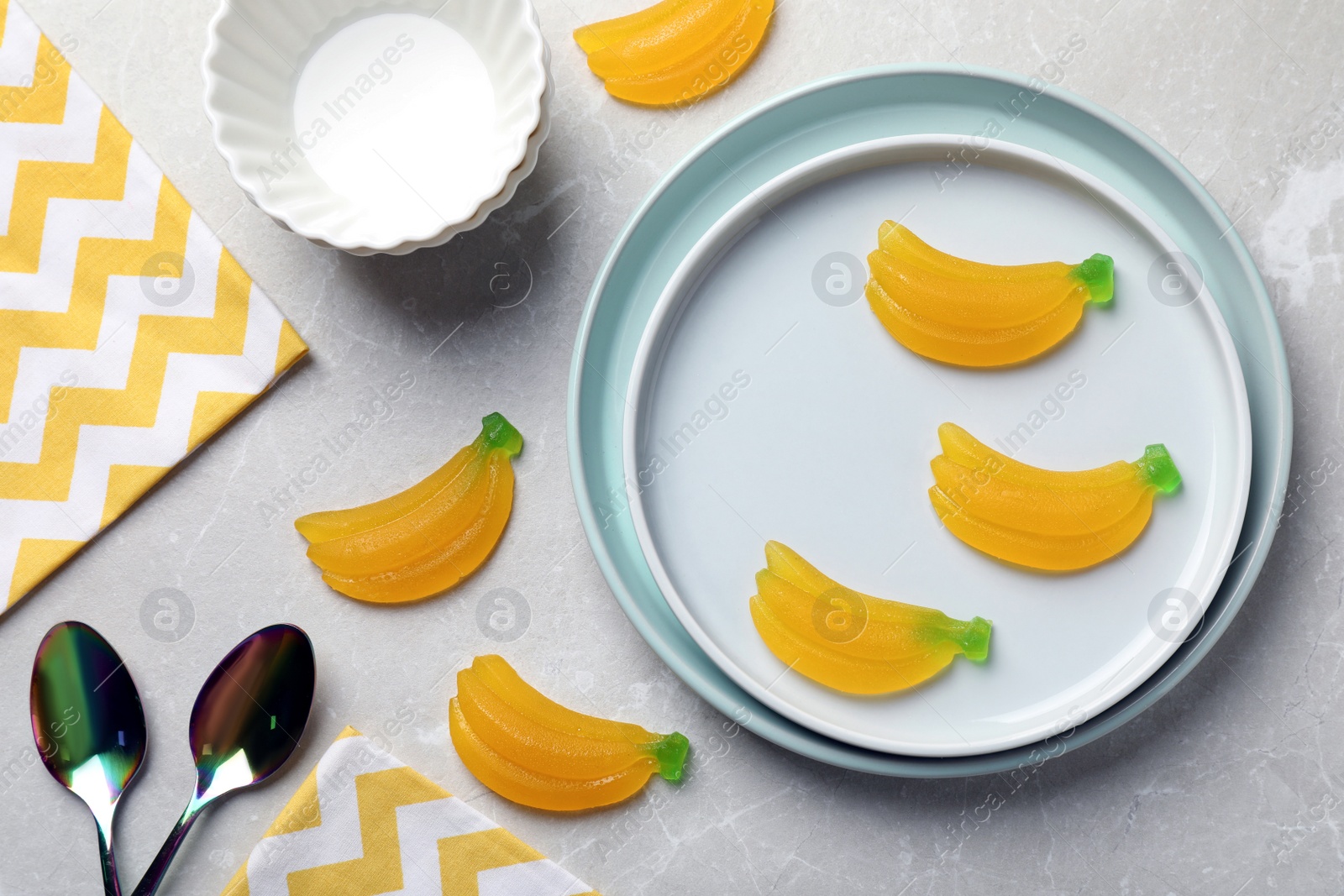 Photo of Flat lay composition with delicious gummy banana candies on light grey table