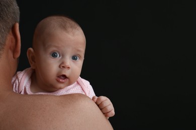 Photo of Father with his little baby on black background. Space for text