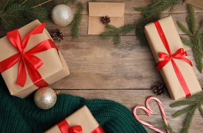 Photo of Frame made with gift boxes and Christmas decor on wooden table, flat lay. Space for text