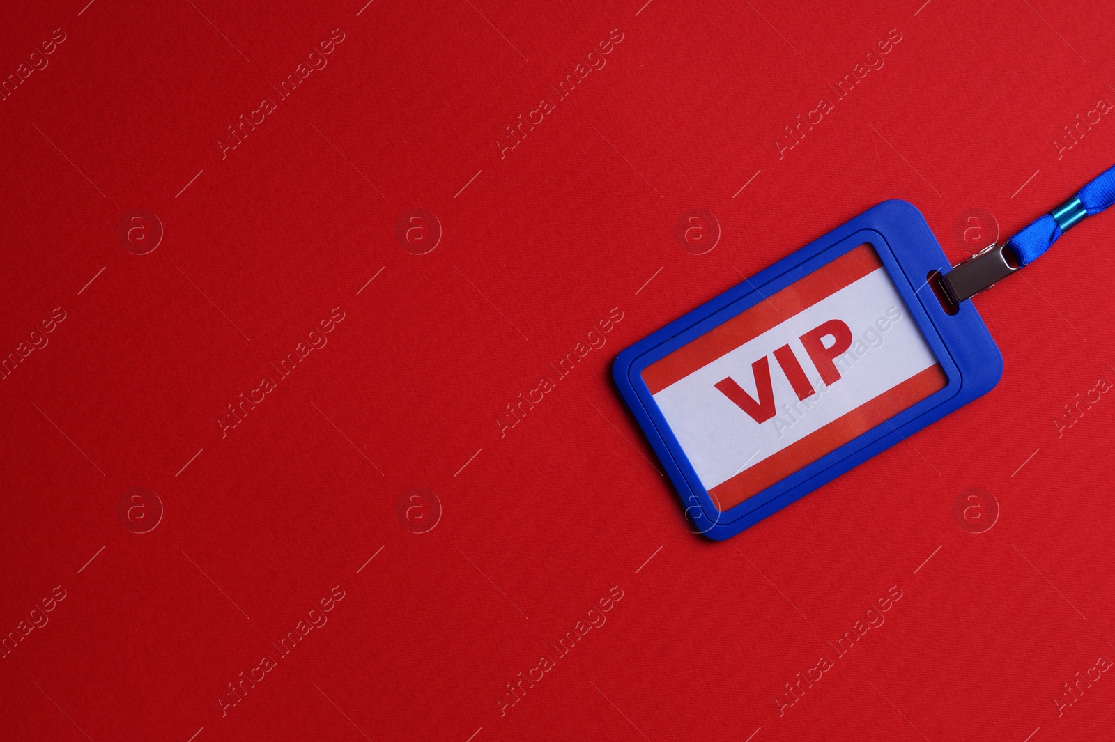 Photo of Plastic vip badge on red background, top view. Space for text