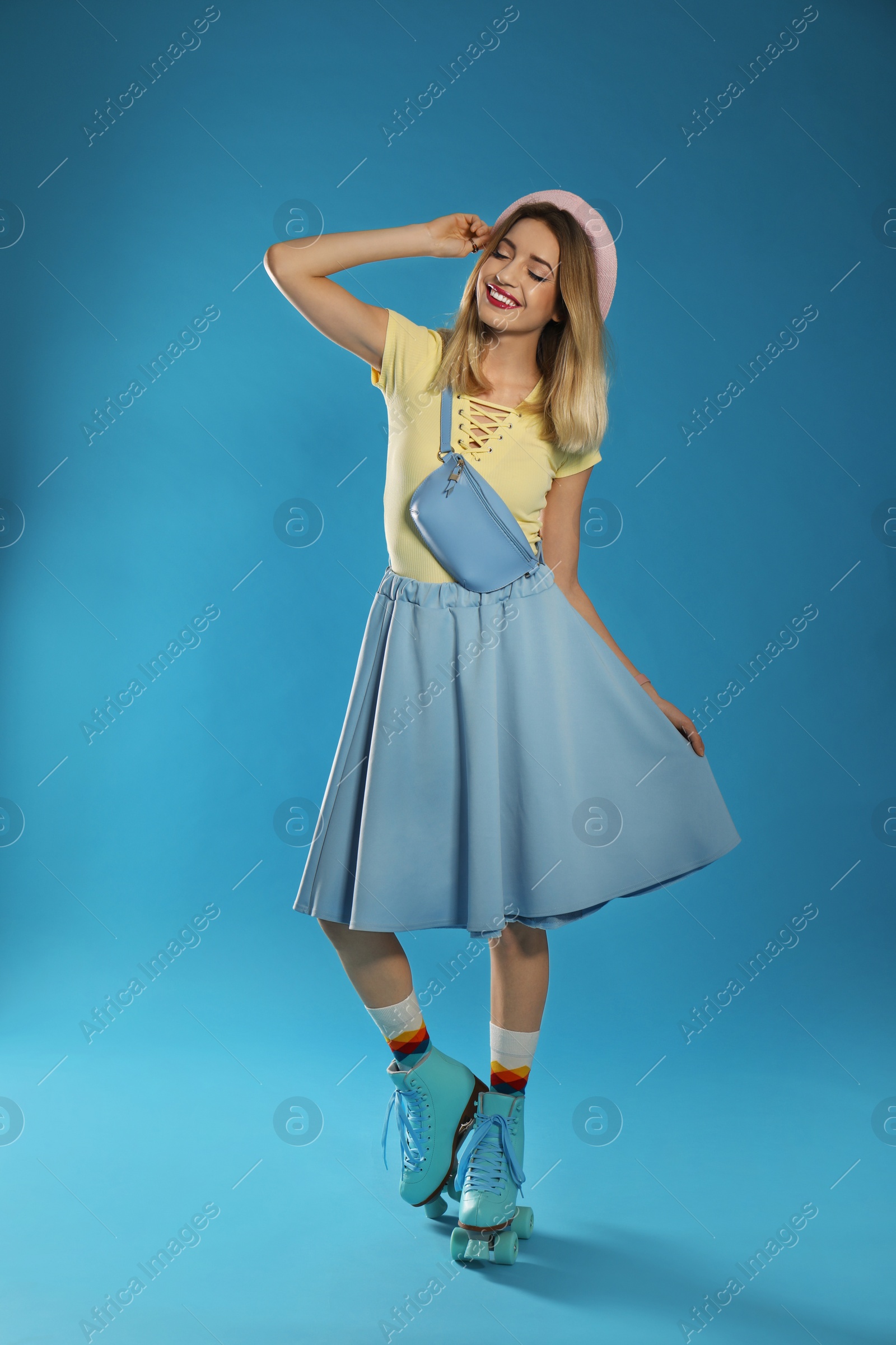 Photo of Young woman with retro roller skates on color background