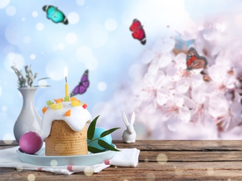 Image of Delicious Easter cake and dyed eggs on wooden table outdoors, space for text