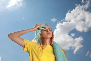 Photo of Woman with towel suffering from heat stroke outdoors