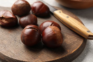 Photo of Fresh edible sweet chestnuts on grey table, closeup