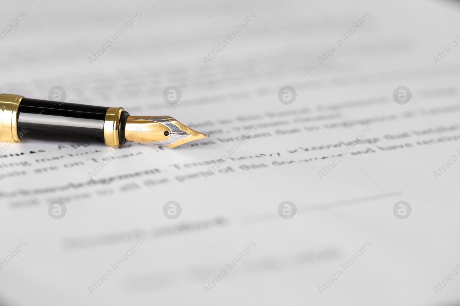 Photo of Fountain pen on document, closeup and space for text. Notary contract