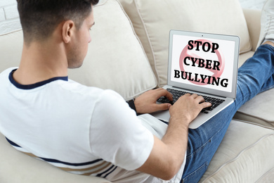 Image of Young man using laptop at home. Cyber bullying