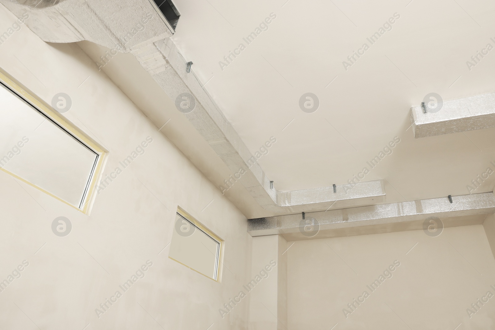 Photo of Ceiling with ventilation system indoors, low angle view