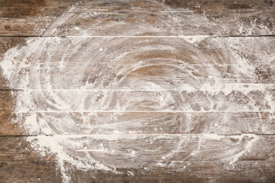 Scattered flour on wooden table, top view