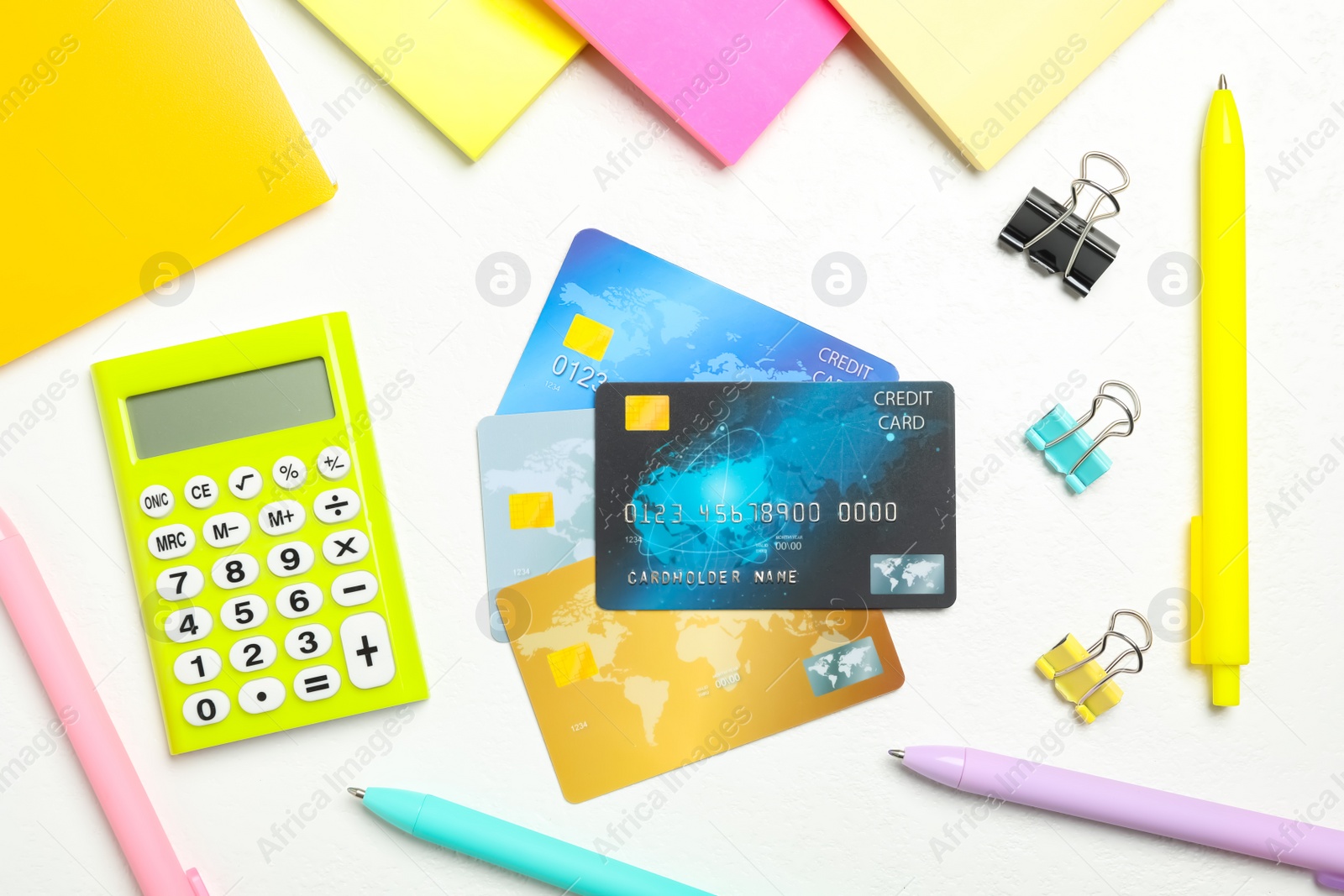 Photo of Credit cards, calculator and stationery on white table, flat lay