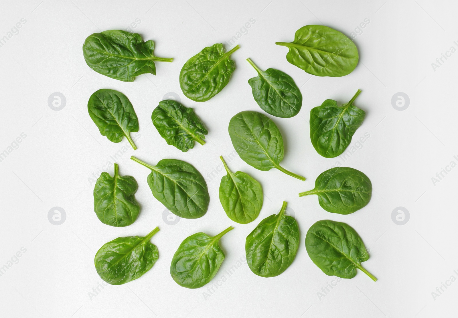 Photo of Fresh leaves of spinach isolated on white, top view