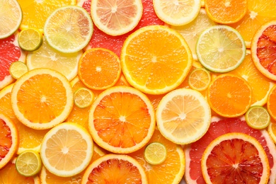 Slices of fresh citrus fruits as background, top view