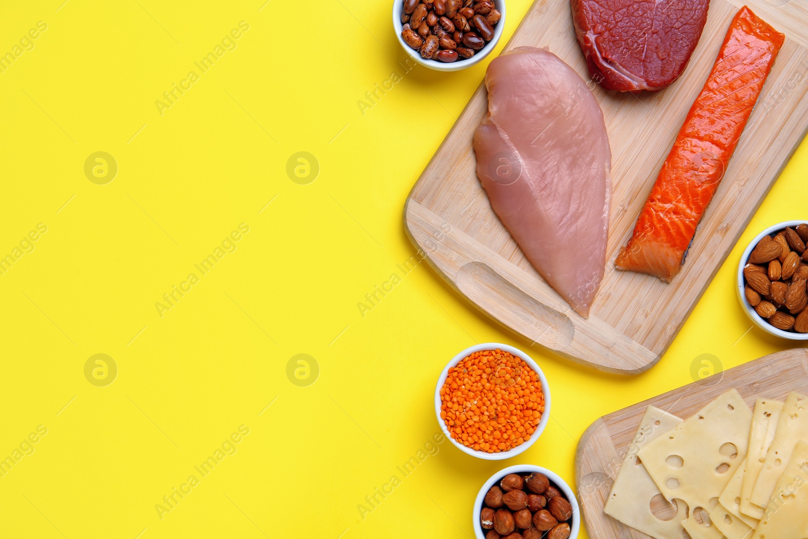 Photo of Different fresh products on yellow background, flat lay. and space for text Sources of essential amino acids