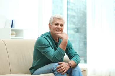 Photo of Portrait of handsome mature man on sofa indoors