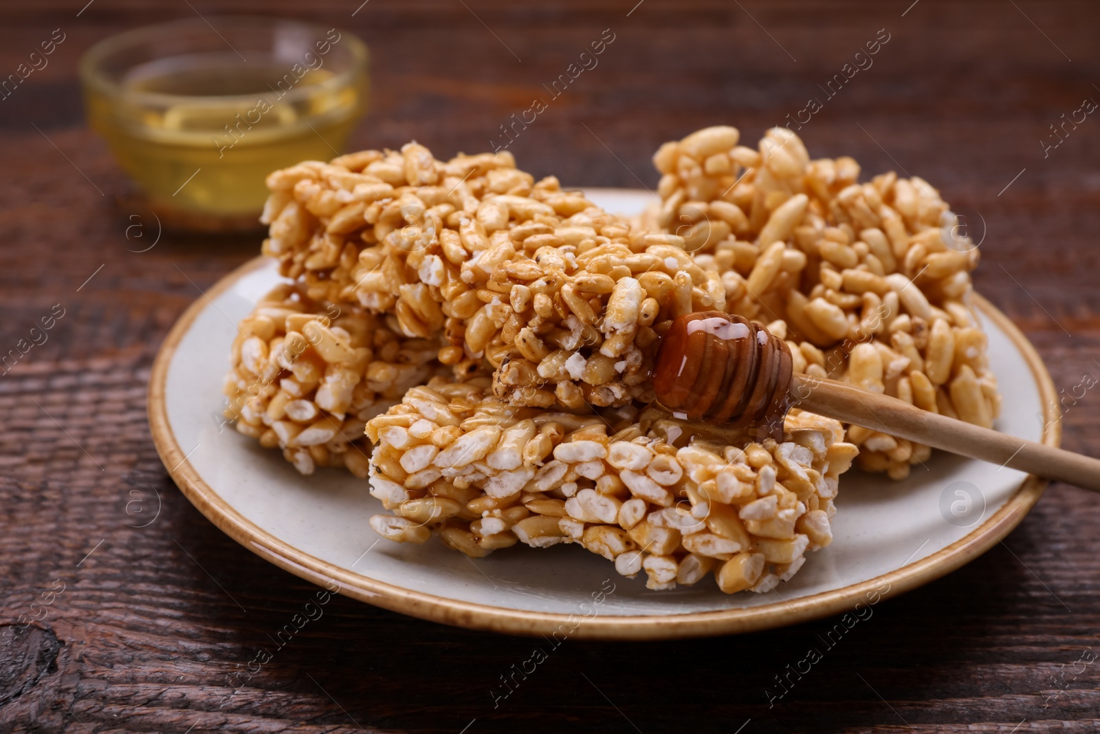 Photo of Plate with puffed rice bars (kozinaki) on wooden table, closeup