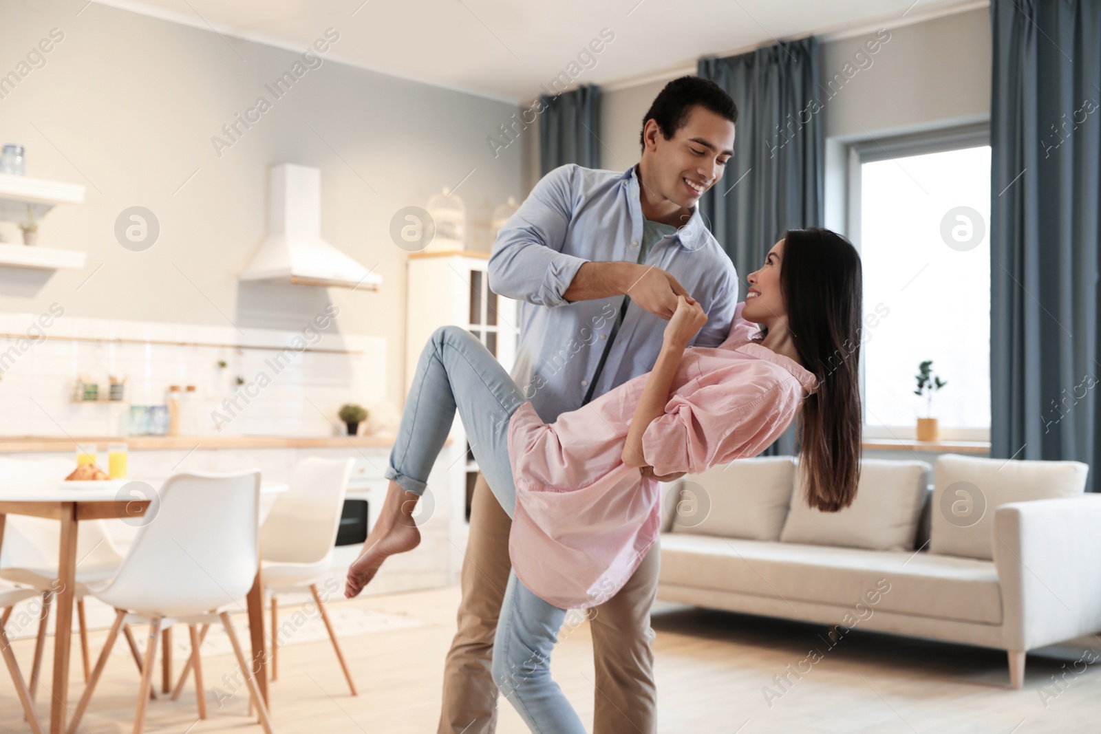 Photo of Lovely young interracial couple dancing at home