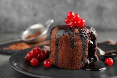 Delicious warm chocolate lava cake with berries on plate, closeup