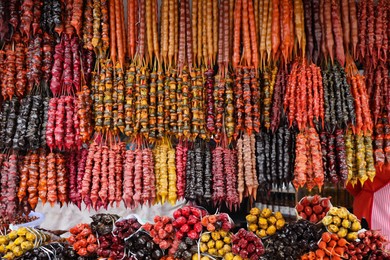 Photo of Bunches of different delicious churchkhelas at market