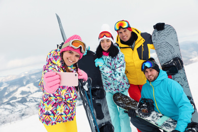 Group of friends taking selfie in snowy mountains. Winter vacation