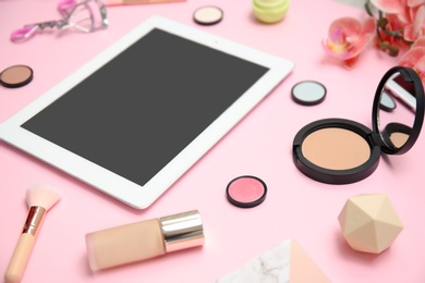 Photo of Composition with tablet and makeup products for woman on color background