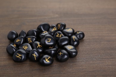 Pile of black rune stones on wooden table