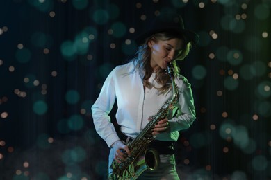 Beautiful young woman playing saxophone on dark background. Bokeh effect
