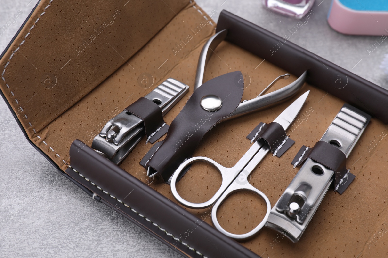 Photo of Kit of pedicure tools on light gray table, closeup