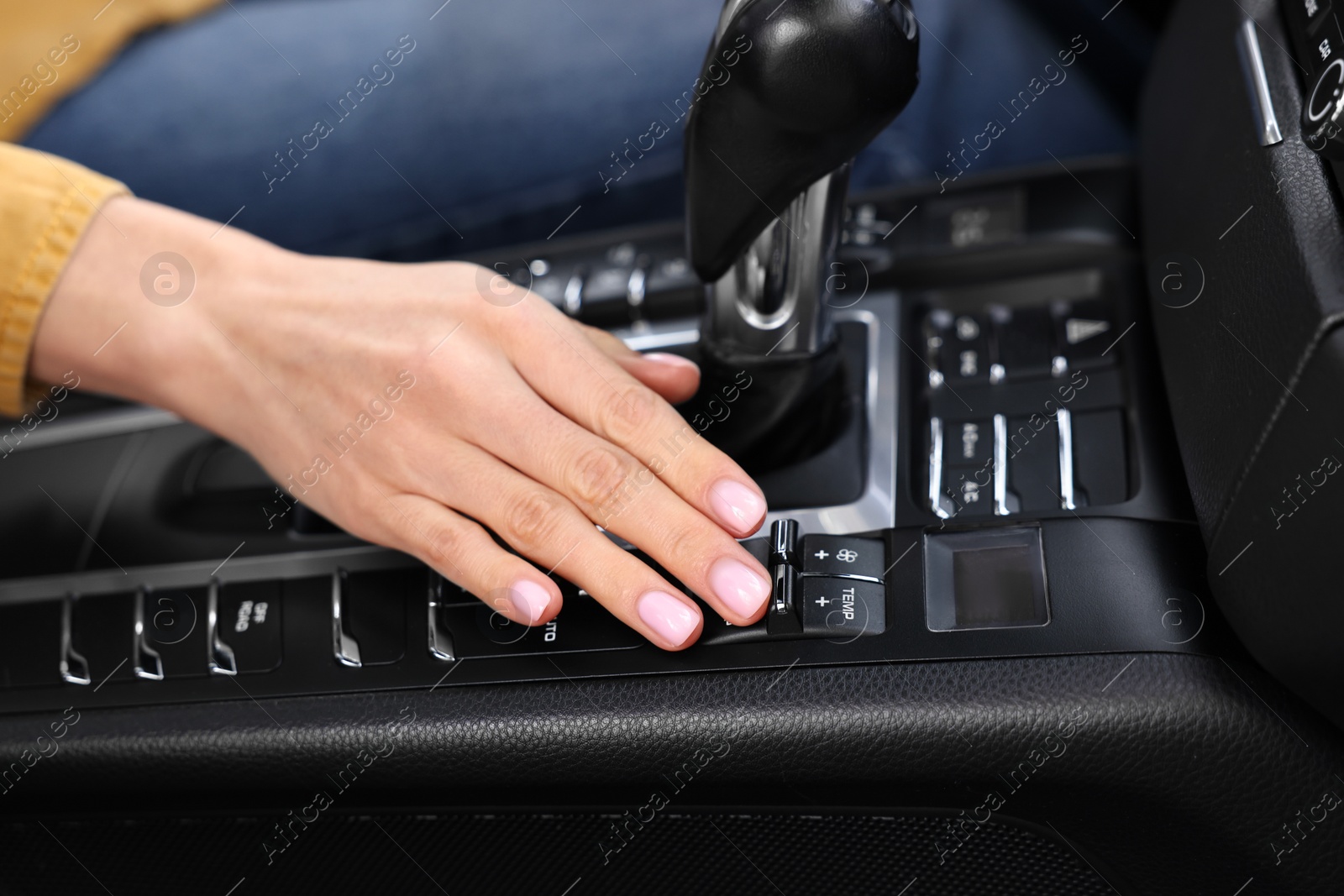 Photo of Woman using gear stick while driving her car, closeup