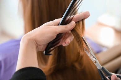 Photo of Professional hairdresser working with client in salon