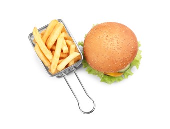 Photo of French fries in frying basket and tasty burger on white background, top view