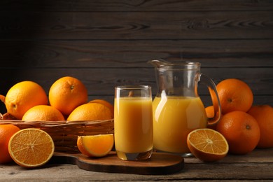 Tasty fresh oranges and juice on wooden table