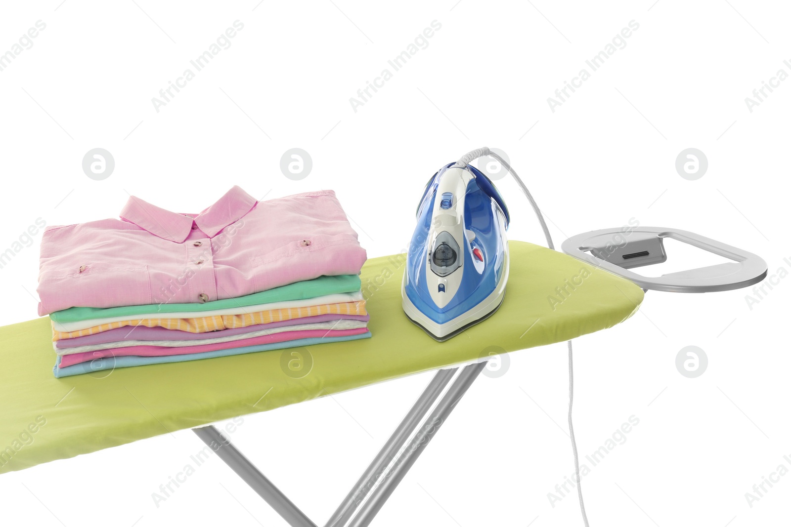 Photo of Board with modern iron and clean laundry on white background