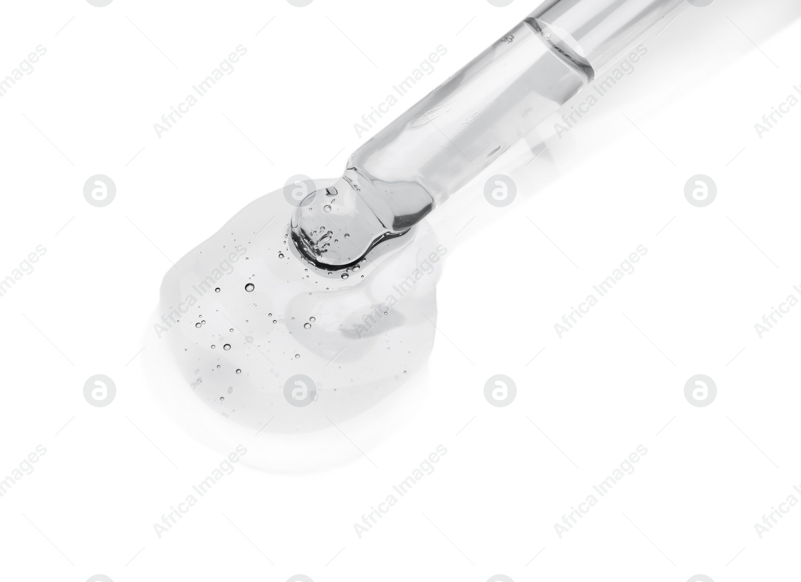 Photo of Dripping cosmetic oil from pipette onto light surface, closeup