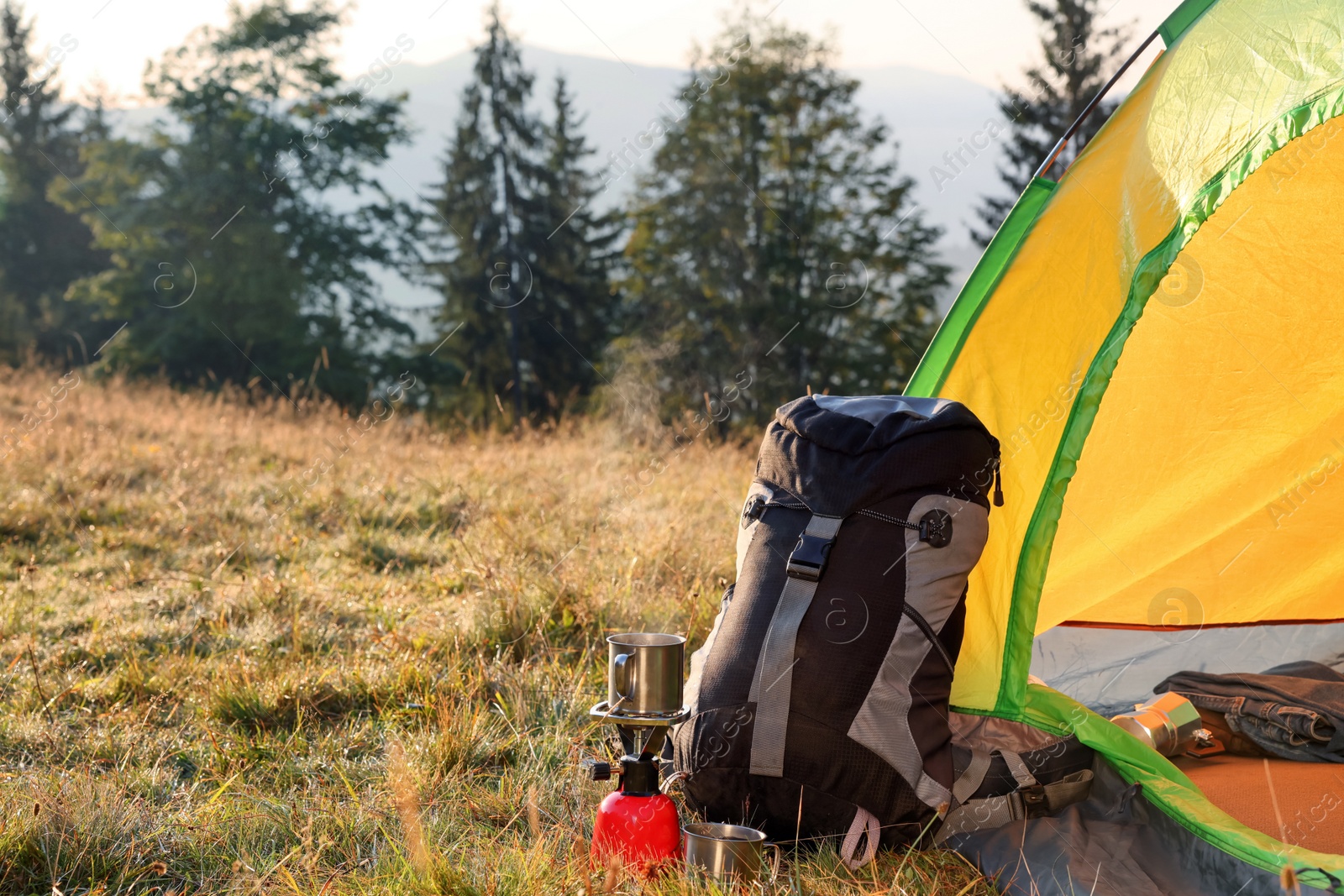 Photo of Backpack and tourist equipment near camping tent in nature
