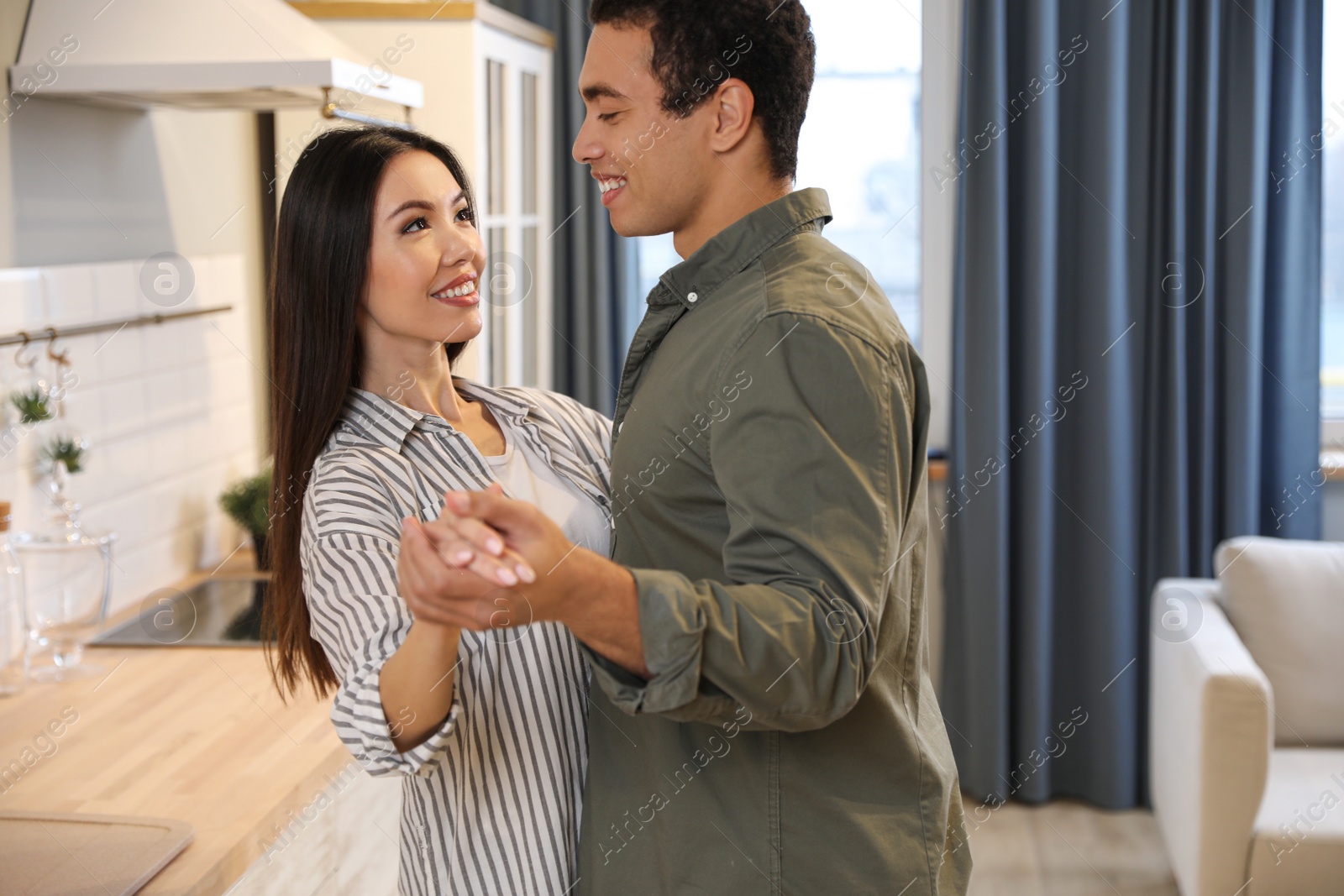 Photo of Lovely young interracial couple dancing at home