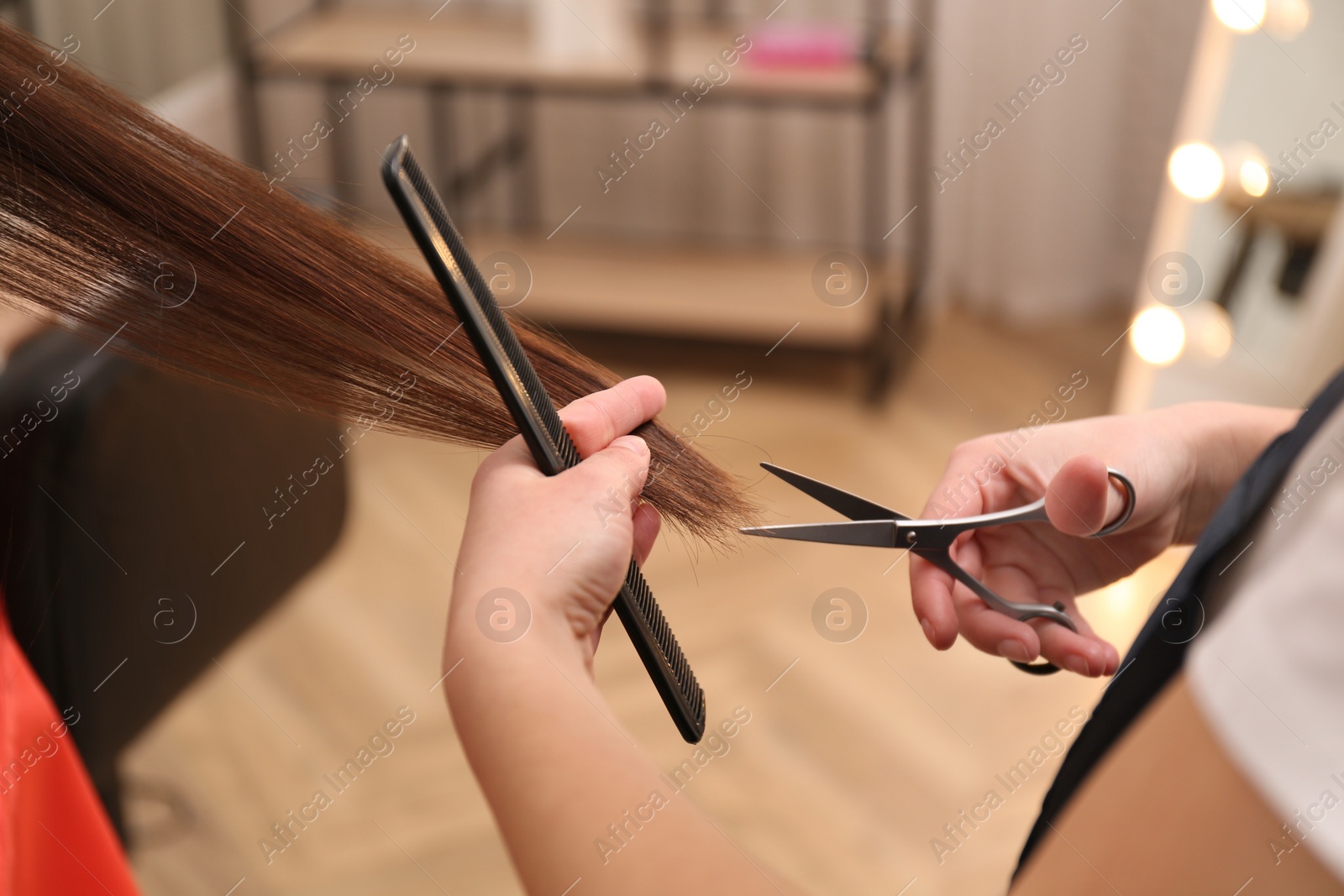 Photo of Stylist cutting hair of client in professional salon, closeup