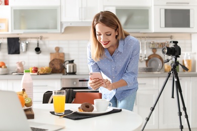 Food blogger taking photo of breakfast in kitchen