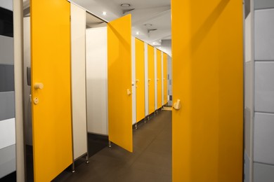 Photo of Public toilet interior with bright yellow stalls