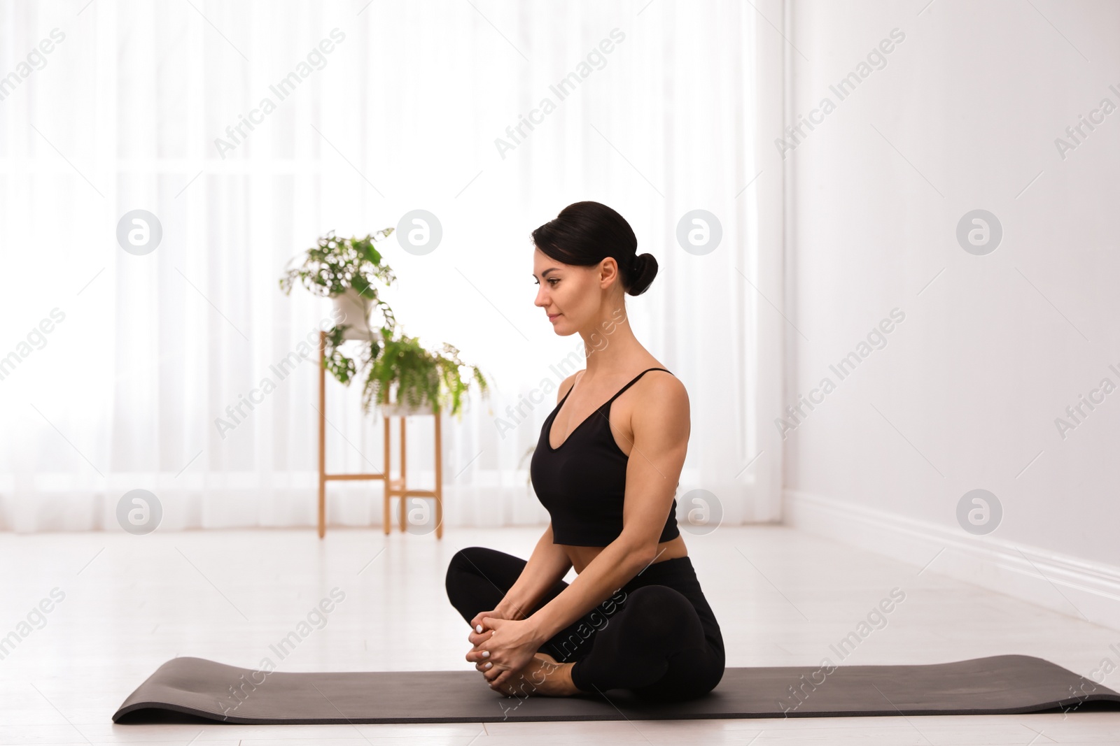 Photo of Professional young acrobat practicing yoga at home