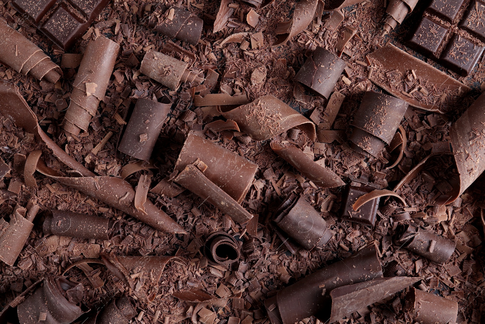 Photo of Yummy chocolate curls for decor as background, top view