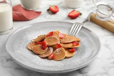 Photo of Delicious mini pancakes cereal with strawberries served on white marble table