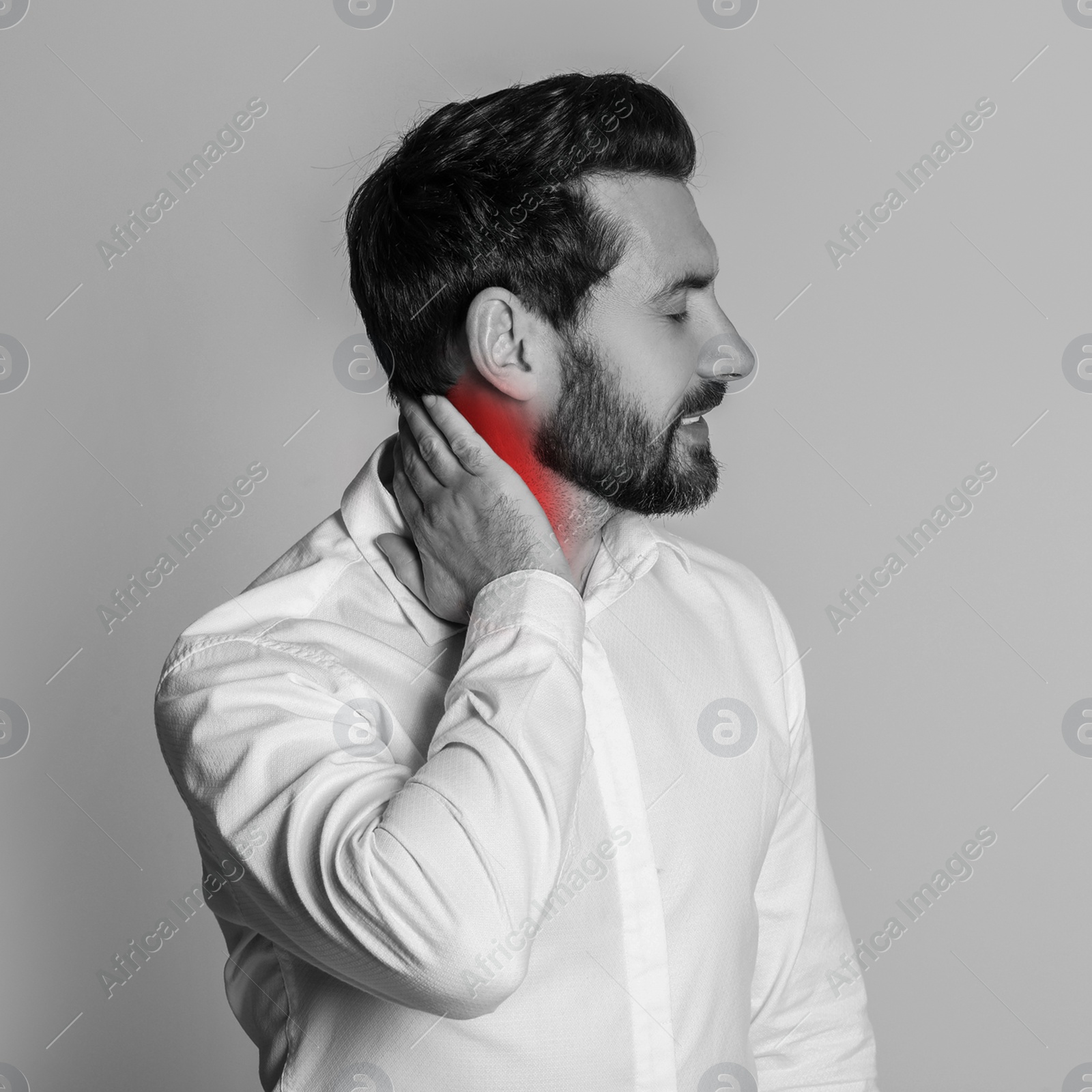 Image of Man suffering from rheumatism on light background. Black and white effect with red accent in painful area