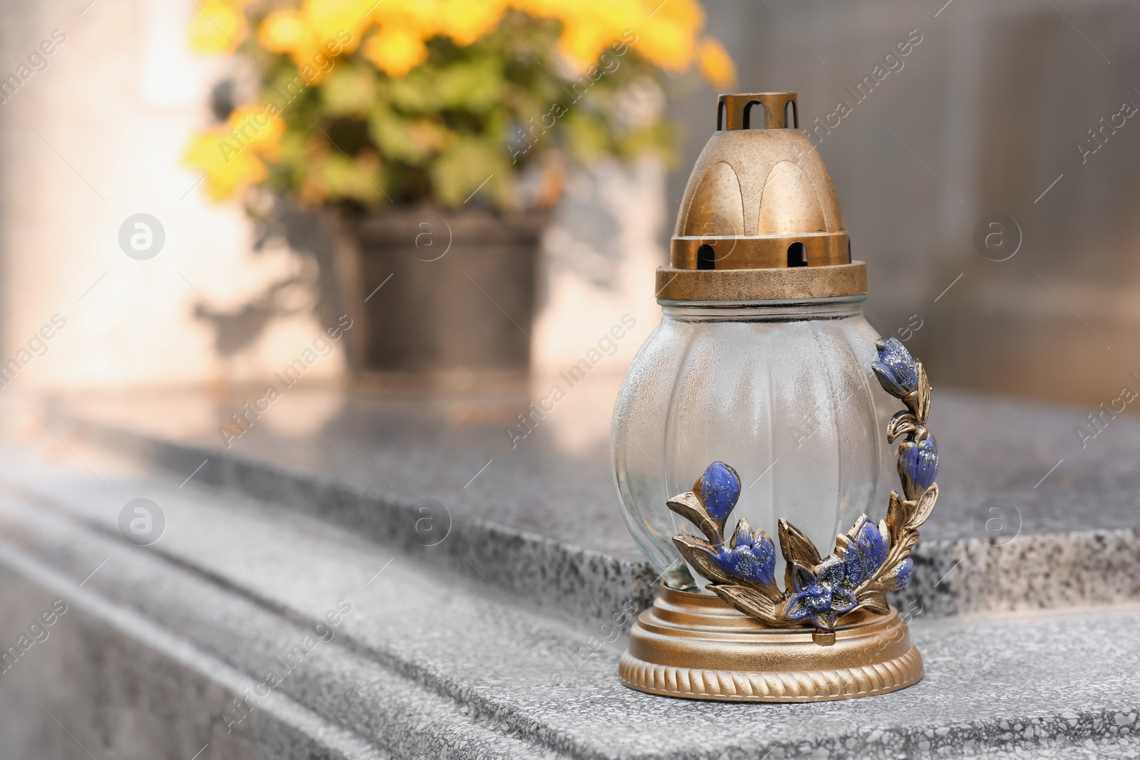 Photo of Grave lantern on granite surface in cemetery, space for text