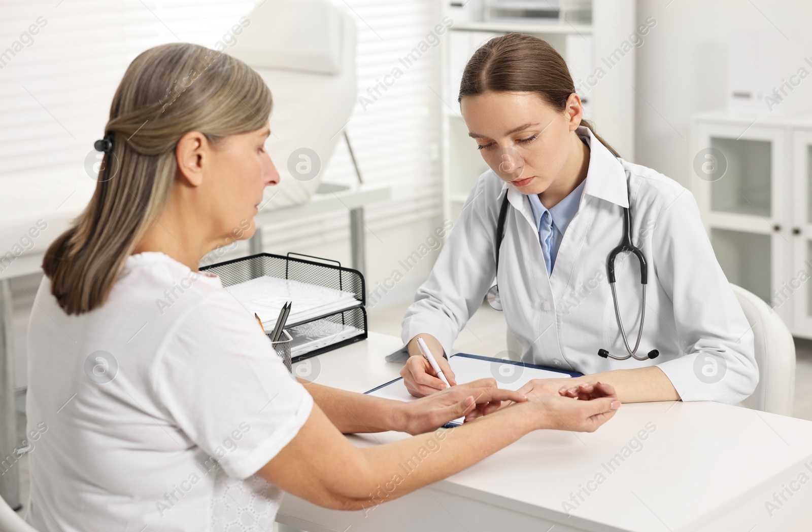 Photo of Arthritis symptoms. Doctor examining patient's wrist in hospital