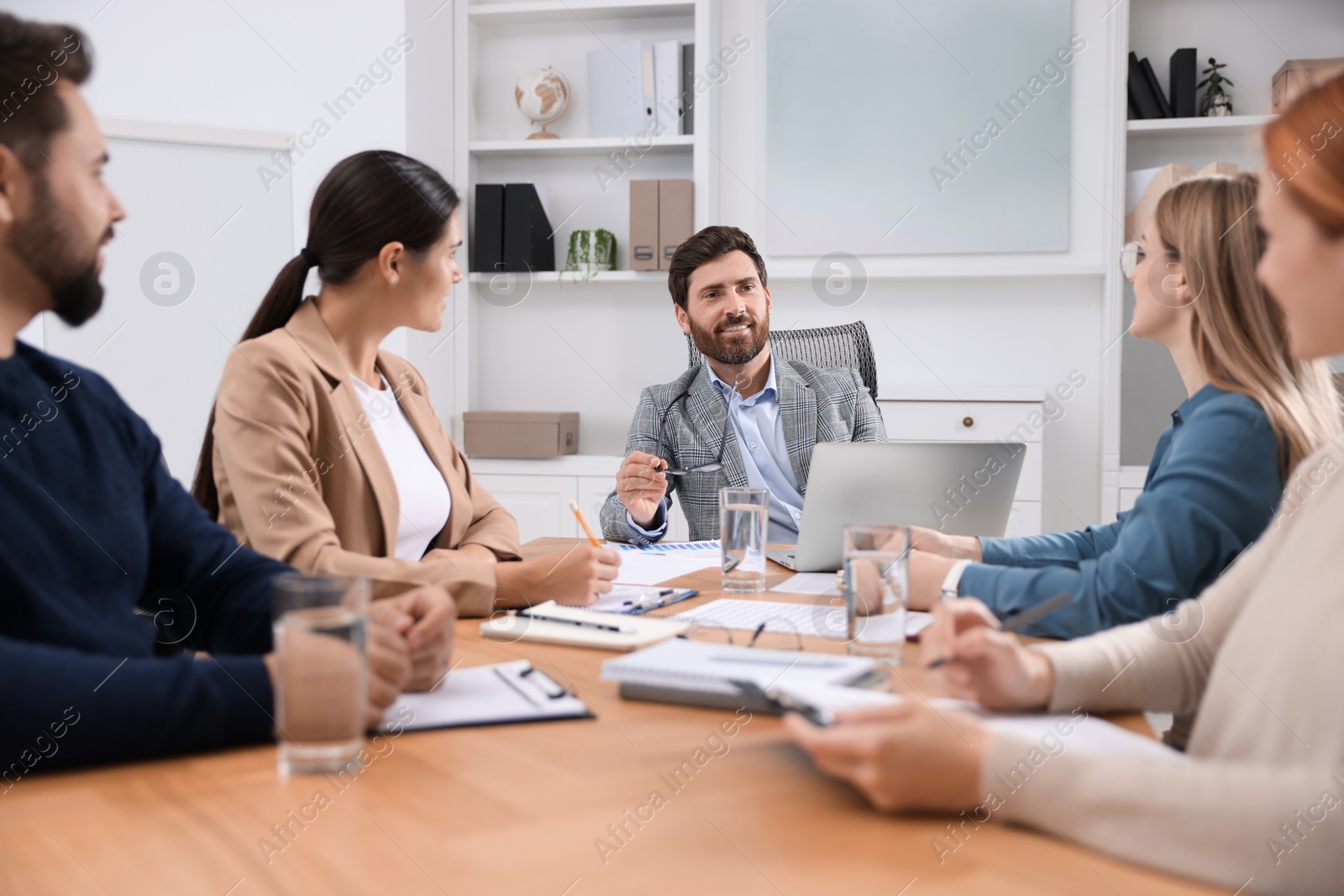 Photo of Team of employees working together in office