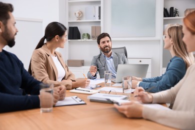 Photo of Team of employees working together in office