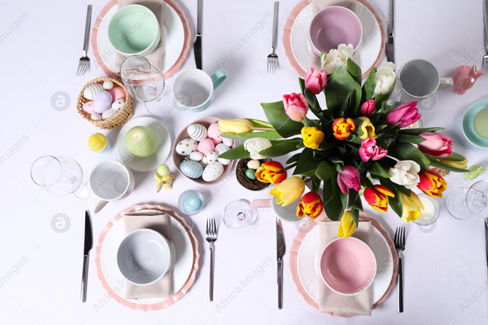 Photo of Festive table setting with beautiful flowers, flat lay. Easter celebration