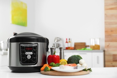 Photo of Modern multi cooker and products on kitchen table