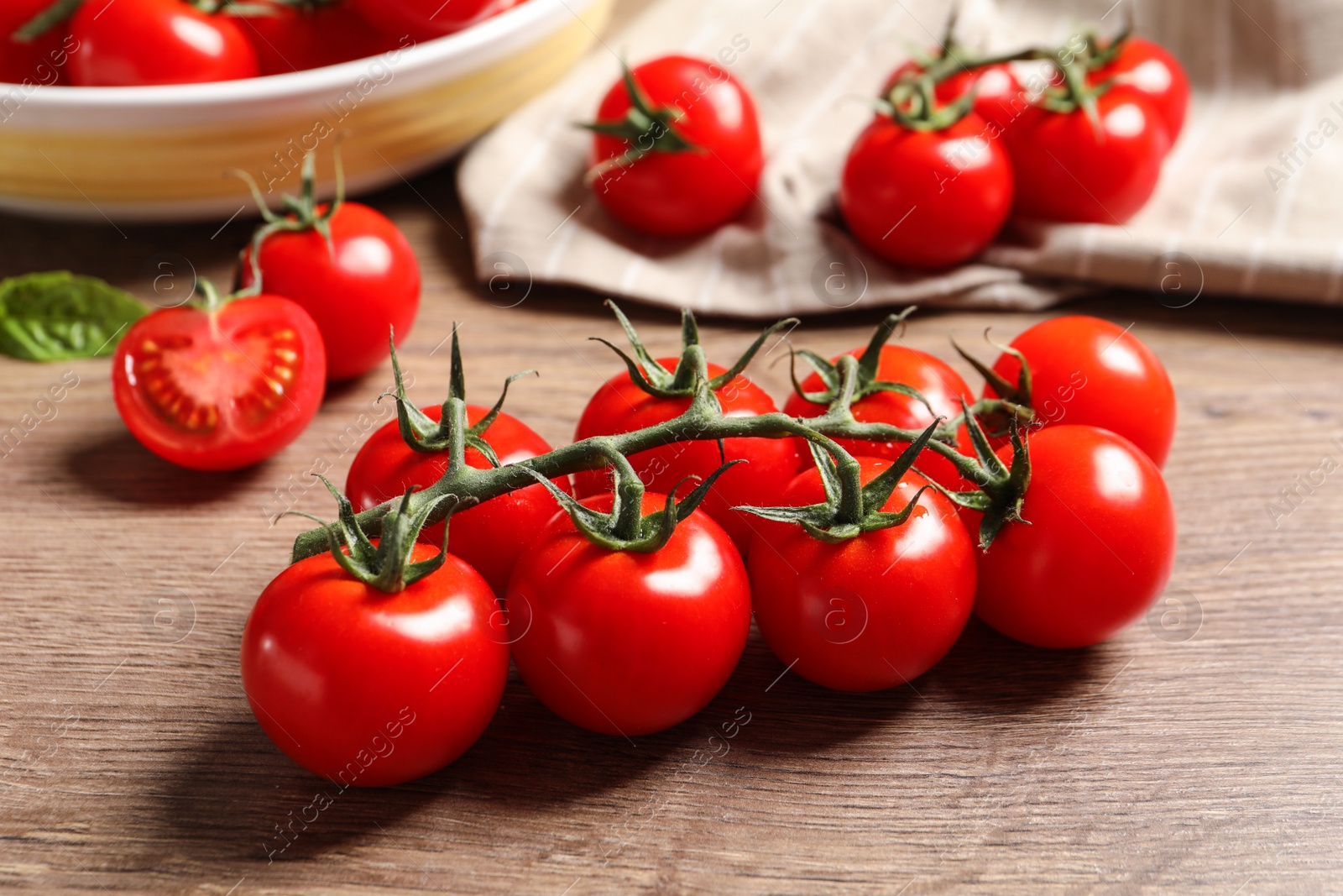 Photo of Branch of cherry tomatoes on wooden background